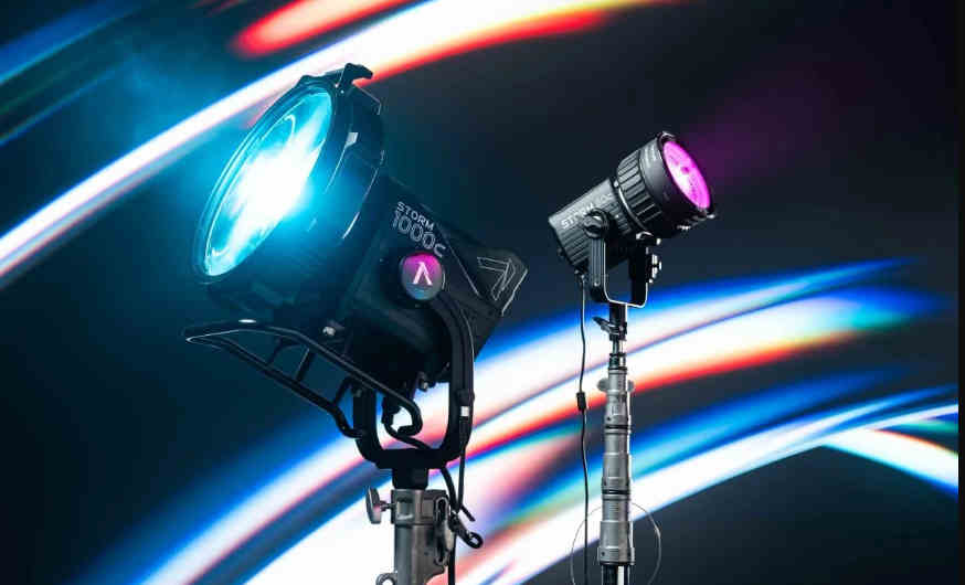 Моноблоки Aputure STORM 1000c та компактний STORM 80c на студійних стійках C-Stand випромінюють блакитне та пурпурове світло на тлі неонових шлейфів